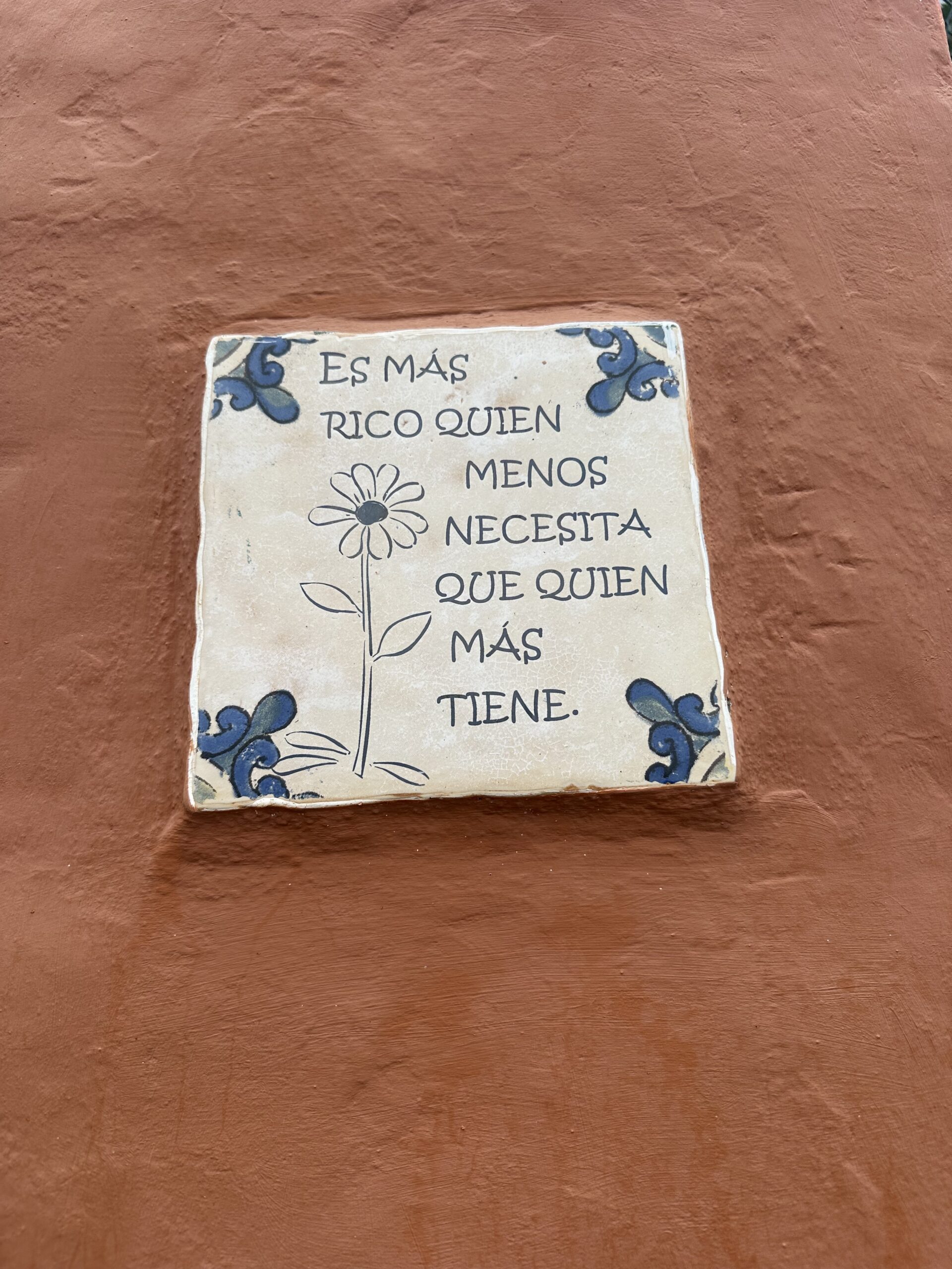 Hand-painted tile on a trail reading 'Es más rico quien menos necesita que quien más' - Gran Canaria